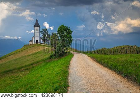 Countryside Landscape With Cute Church On The Mountain Ridge. Cloudy Scenery And Famous Alpine Saint