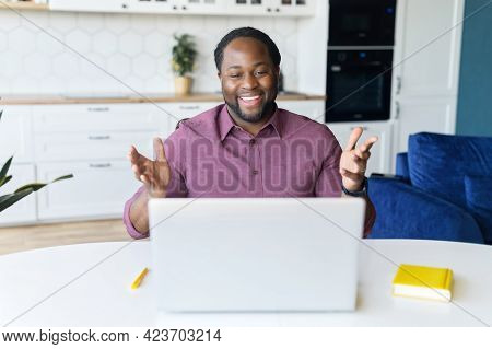Hilarious African-american Male Freelancer Wearing Casual Shirt Using Laptop For Video Call At Home,