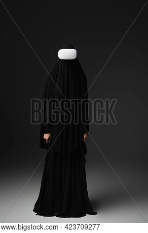 Full Length View Of Muslim Nun In Black Abaya And Vr Headset On Black Background