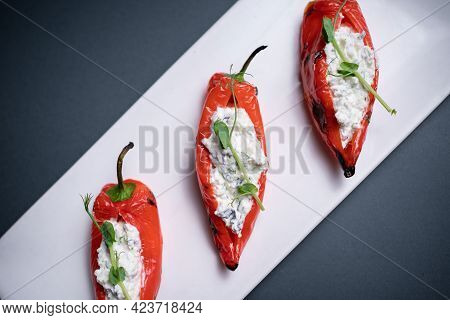 Top View Of Bulgarian Peppers Stuffed With Cottage Cheese On Black Background