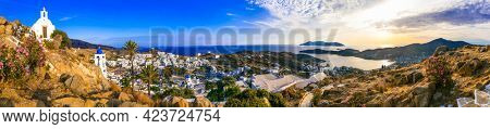 Breathtaking panoramic sunset view of island. Chora town with churches and whitwashed houses. Popular tourist destination in Cyclades, Greece