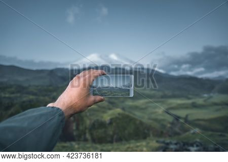 Hiker Man Takingphoto Mountain Elbrus With Cell Phone.