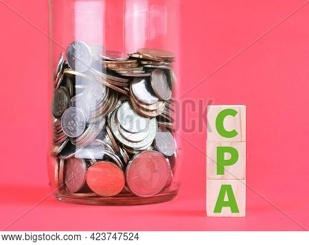 Cost Per Action Concept. Text Cpa On Wooden Cubes With Coins Against Red Background.
