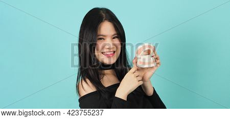 Woman Holding Toothbrush And Dental Teeth Model. Oral Health Care Concept.