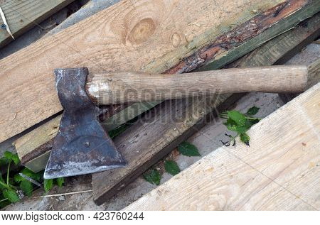Photography on theme big steel axe with wooden handle, metal ax for wood chopping. Photo old ax consisting of one axe on nature background. Forged axe it main accessory male, natural ax for survival.