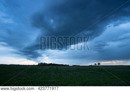 Dramatic Storm Nimbostratus Of Gray-blue Color And Strong Air Flow Over Agricultural Field In Evenin