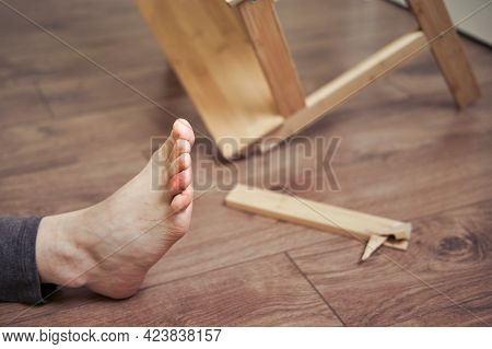 A Man Injured His Toe After Falling From A Wooden Stepladder. Ladder Made Of Wood Broke Under A Man 