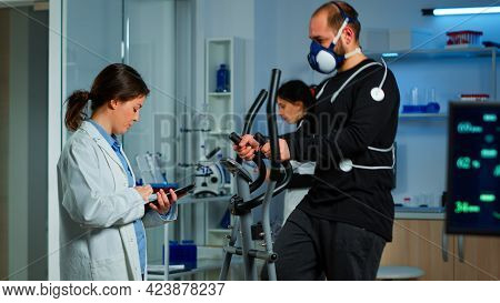 Science Sport Doctor Asking Patient About His Health While Sportsman Running On Cross Trainer With M