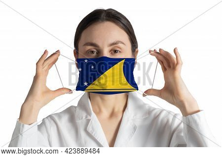 Respirator With Flag Of Tokelau Doctor Puts On Medical Face Mask Isolated On White Background.