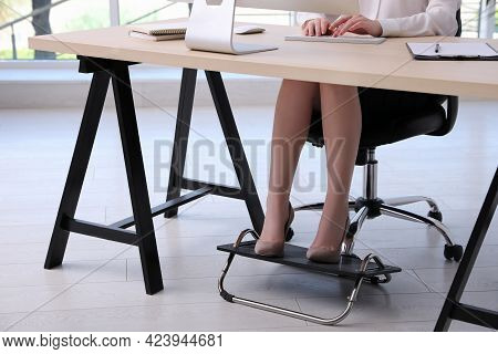 Woman Using Footrest While Working On Computer In Office, Closeup