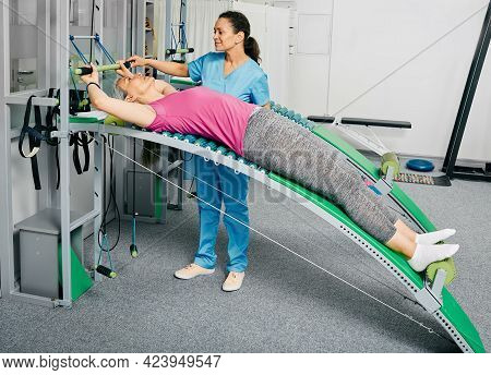 Recovery Exercises For A Mature Womans Back And Arms Using Medical Equipment And Trainer Machine Wit