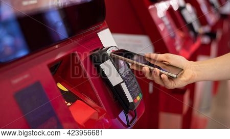 Faceless Caucasian Woman Pays At Selfservice Machine With Contactless Phone Payment.