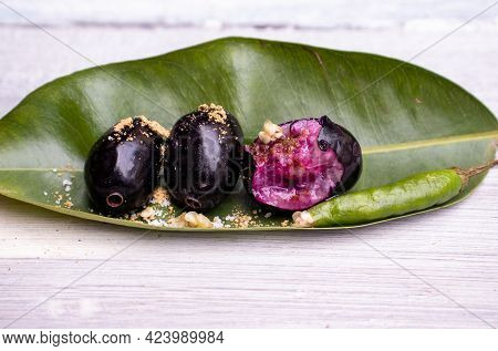 Closeup Of Malabar Plum Or Jamun On Leaf Coated With Salt And Spices Isolated On Wooden Background, 