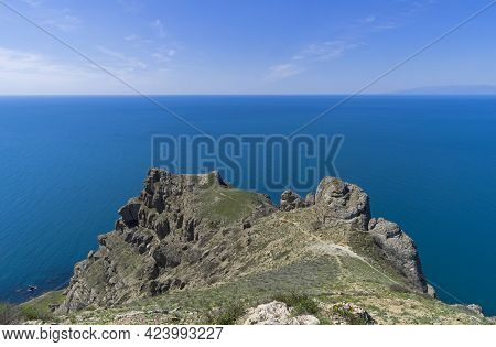 Steep Rocky Cliff Above The Sea. Cape Meganom, Crimea. Sunny Day At The End Of Apri