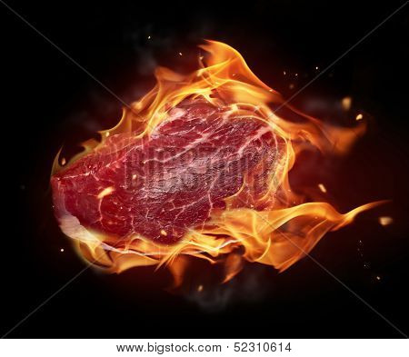 Concept of burning raw beef steak isolated on black background