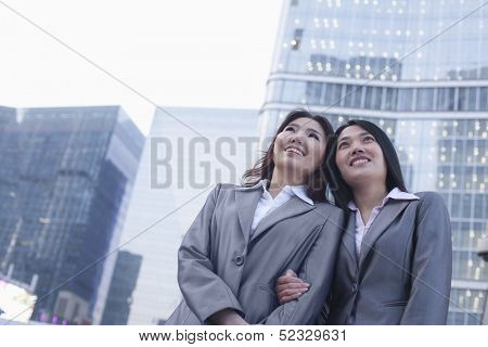 Portrait of smiling businesswomen linking arms