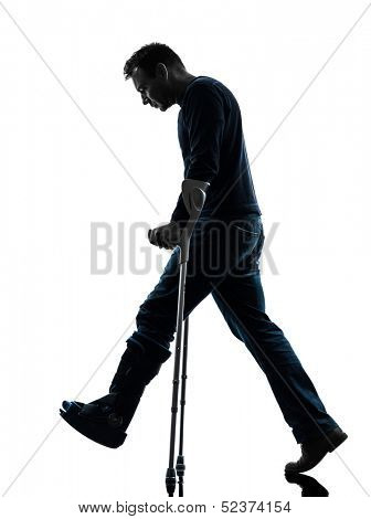 one  man injured man walking sad with crutches in silhouette studio  on white background