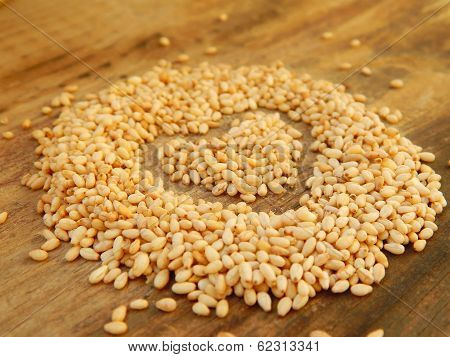 Sesame seeds in a shape of heart isolated on wooden background