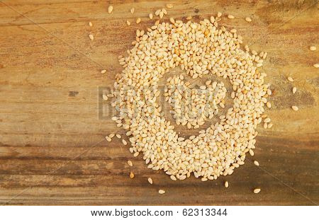 Sesame seeds in a shape of heart isolated on wooden background