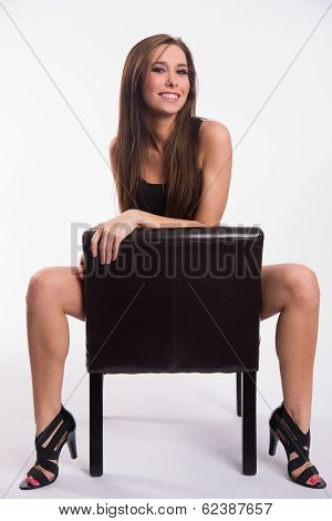 Stunning Young Beautiful Barefoot Woman Straddles Black Leather Chair