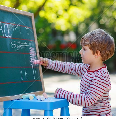 Little Boy At Blackboard Practicing Mathematics