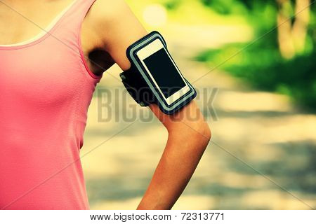 Runner athlete listening to music from smart phone mp3 player smart phone armband.