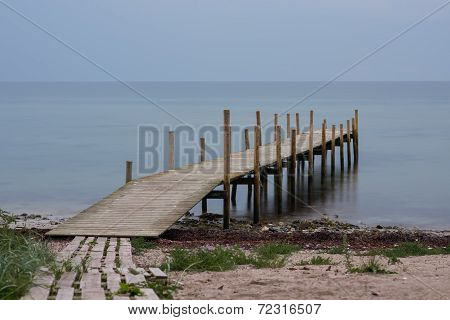 Wooden Pier On Beach In A Gloomy Predawn