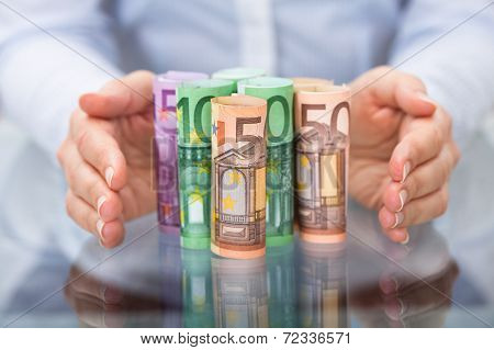 Hand Protecting Rolled Up Euro Banknote