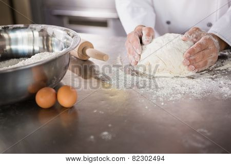 Close up of baker preparing dough in the kitchen of the bakery