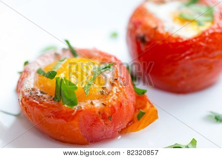 Baked, de-seeded tomatoes filled with an egg and finished in the oven, served on toast with a parsley garnish. This Italian dish is uova al piatto con pomodori