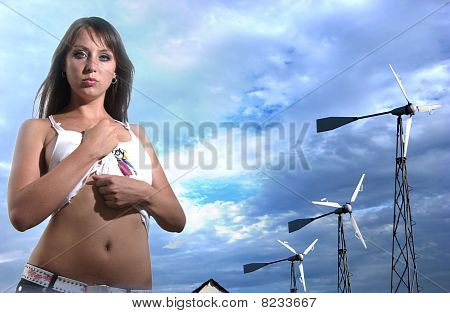 Ragazza con Windgenerators contro il cielo nuvoloso