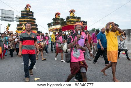KUALA LUMPUR, MALAYSIA - FEBRUARY 3, 2015: Hindu devotees carry milk pots and kavadis walk in a procession to the Batu Caves temple on Thaipusam day, a day of thanksgiving and devotion.