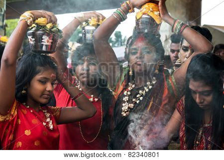 KUALA LUMPUR, MALAYSIA - FEBRUARY 3, 2015: Hindu devotees carry milk pots on their heads walk in a procession to the Batu Caves temple on Thaipusam day, a day of thanksgiving and devotion.