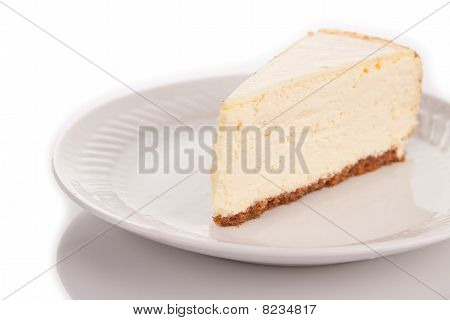Une tranche de gâteau au fromage sur une plaque blanche