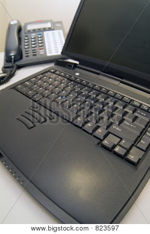 Laptop with phone in background