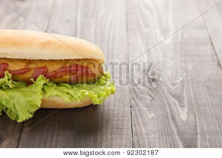 Half Hot Dog With Ketchup On Wooden Background