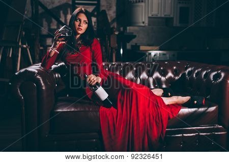 young woman in red dress sitting on leather sofa