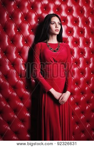 young woman in red dress standing near wall
