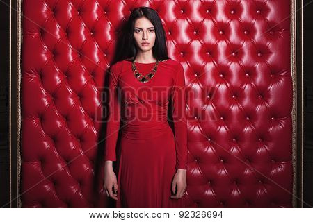 young woman in red dress standing near wall