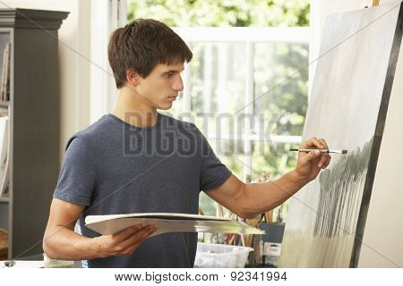 Teenage Boy Working On Painting In Studio