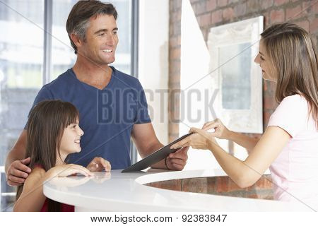 Father With Daughter At Reception Of Dentist's Surgery