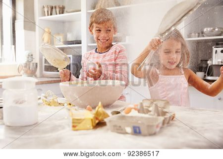Two children having fun baking in the kitchen