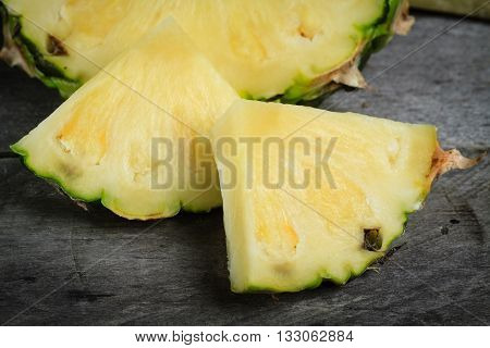 Pineapple chunks on gray wood background. Fresh pineapple.