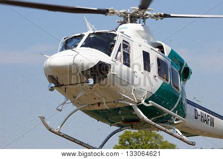 AHLEN GERMANY - JUN 5 2016: Close up view of a Bell 412SP helicopter kicking up grass while landing