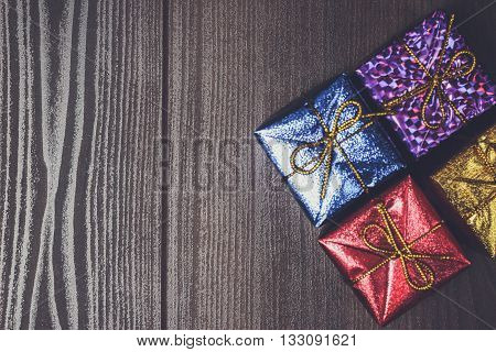 colorful present boxes over brown wooden background