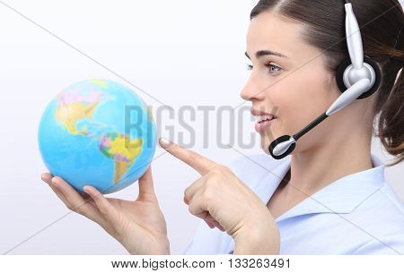 customer service operator woman with headset pointing her finger on globe isolated on white background