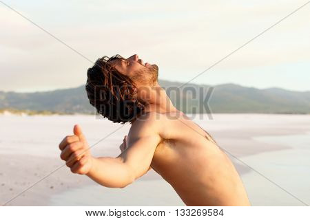 Shirtless Young Man Leaning Back By Beach