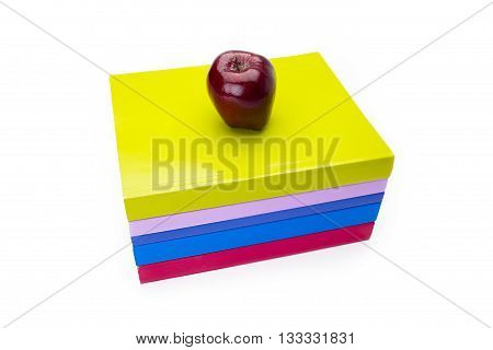a red apple centered on books isolated on a white background