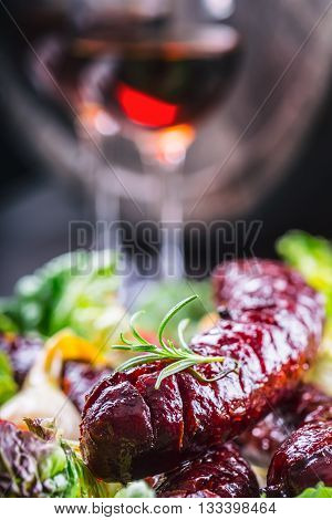 Sausage. Roasted chorizo sausage. Roasted spicy sausage chorizo home hotel or restaurant with beer vine brandy cognac whiskey.Vegetable decoration lettuce salad tomato garlic. Toned photo.