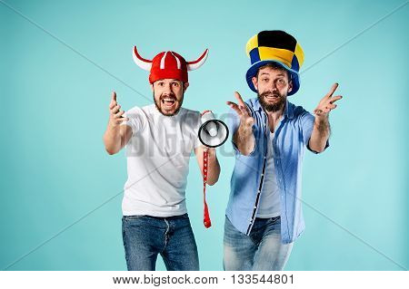 The two football fans with mouthpiece over blue background
